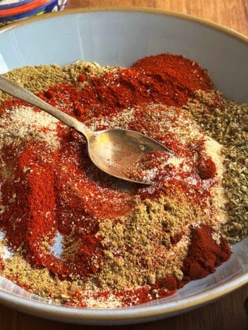 Chicken taco seasoning spices partially mixed in bowl with antique spoon