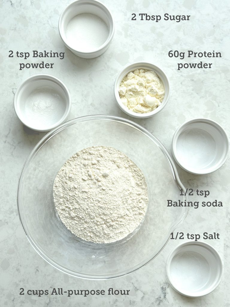 All the dry ingredients are measured and in separate containers laid out on a marble surface.