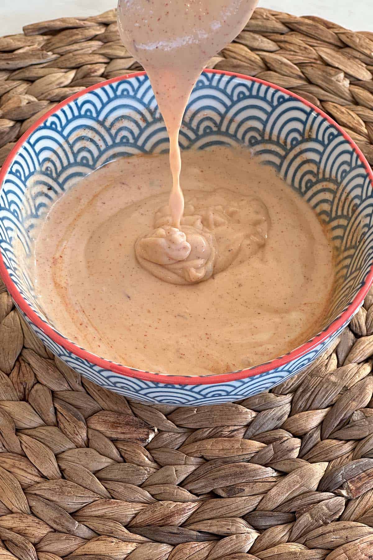 A bowl with all the ingredients for the honey BBQ aioli thoroughly mixed, ready to be used.