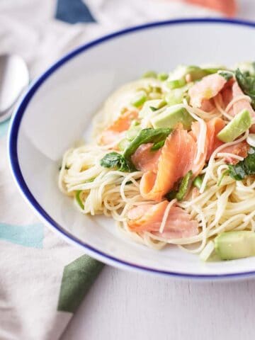 angel hair pasta with slices of smoked salmon, cubed avocado and garnished with watercress and thinly sliced green onions