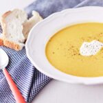 Bowl of pumpkin soup with toasted bread on the side
