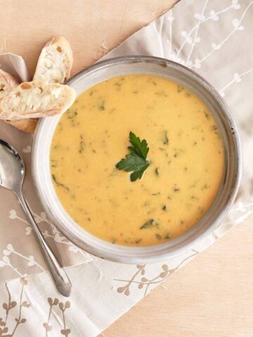 Rustic bowl with pumpkin and white bean soup with fresh herbs in