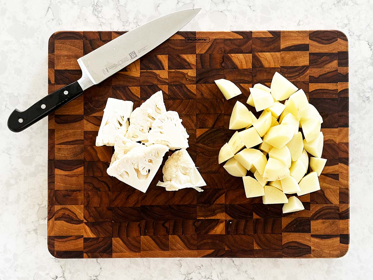 Chopped cauliflower florets and cubed potatoes ready for creamy potato, leek and cauliflower soup.