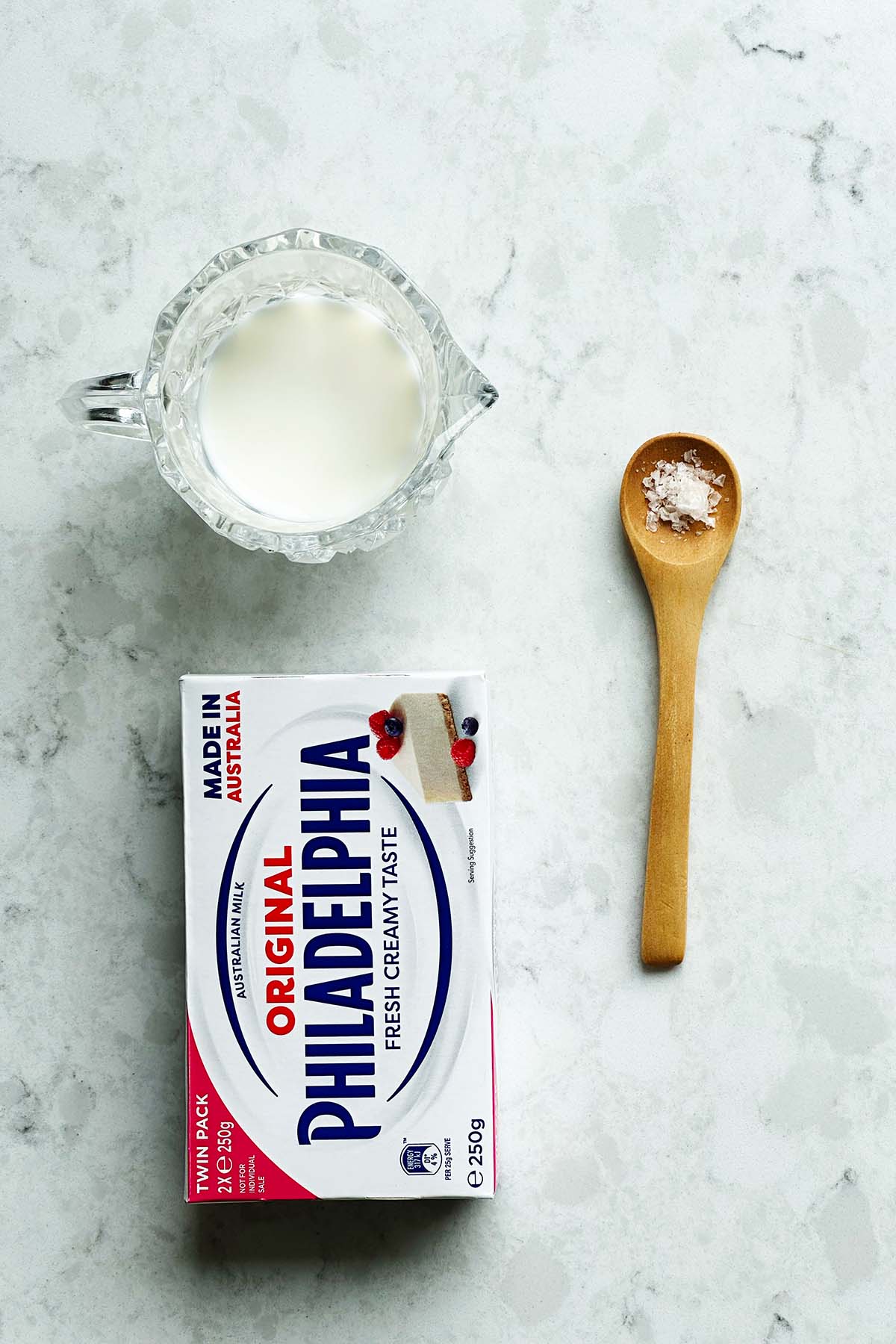 Ingredients for whipped cream cheese on a bench top, Philadelphia cream cheese, cream or milk and salt
