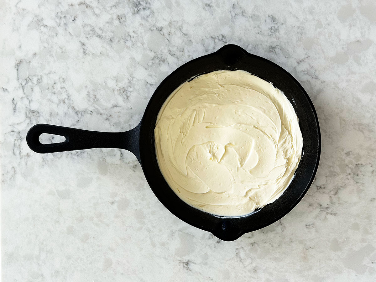 Cream cheese layer in cast iron skillet for chili dip.