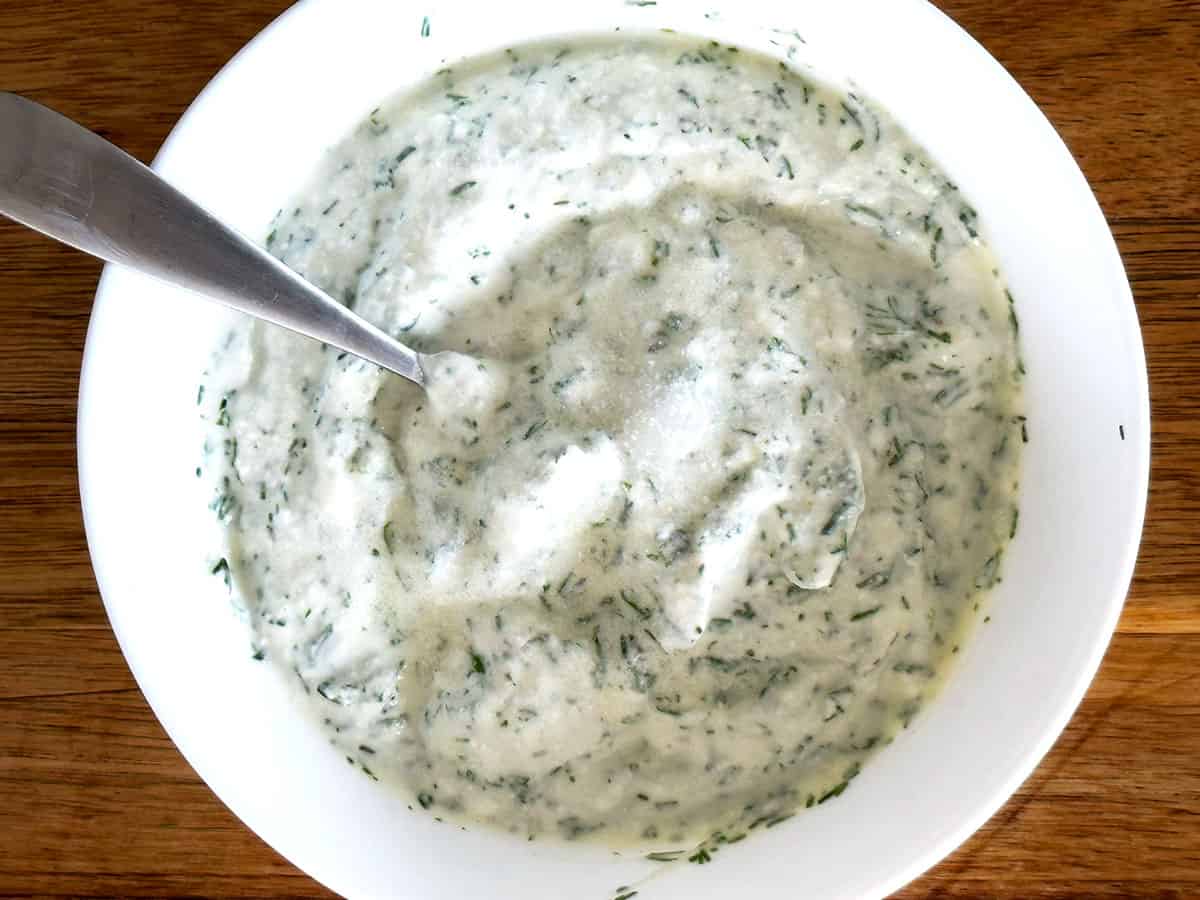 Bowl of mixed dill lemon yoghurt sauce resting before serving