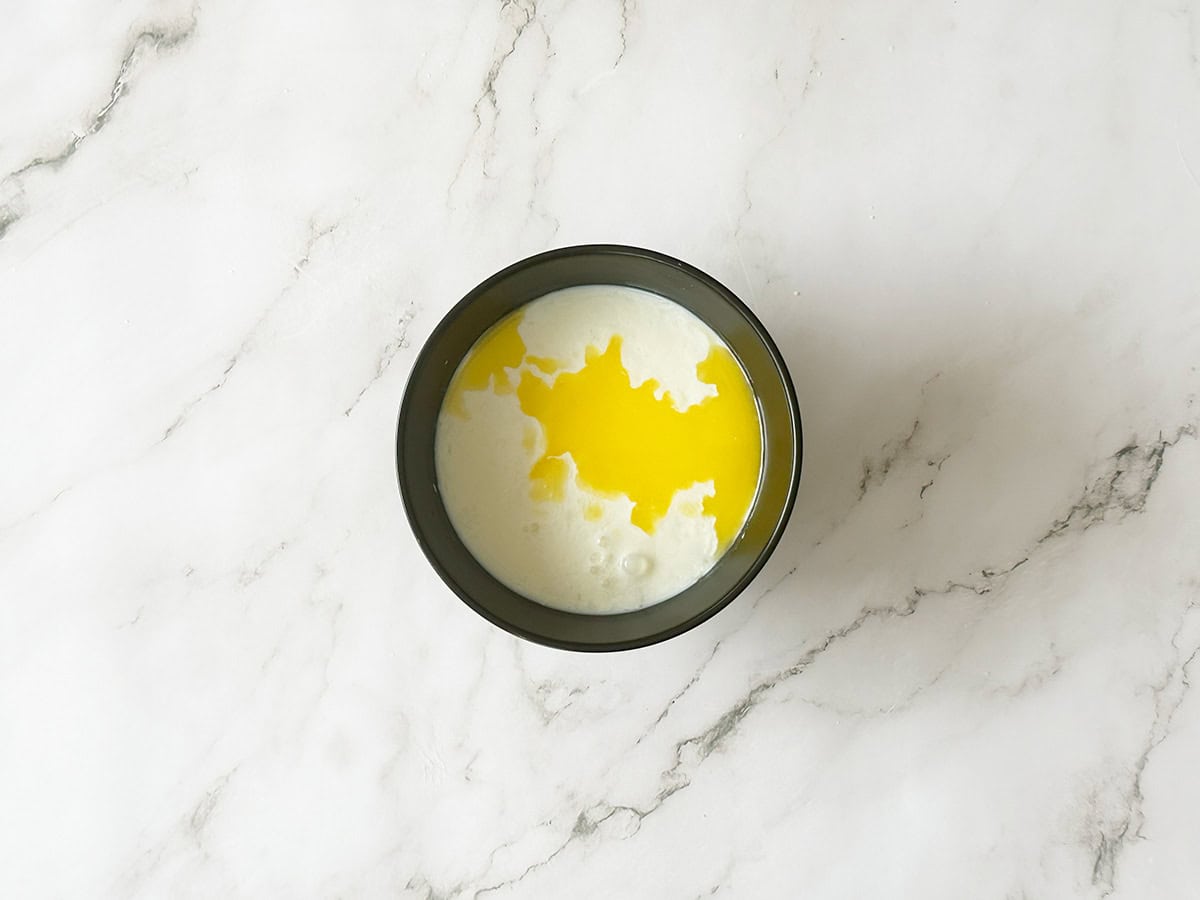 Curdled milk mixture with melted butter added for Malva pudding batter