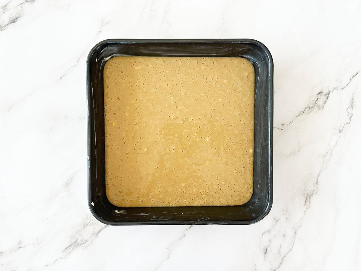 Malva pudding batter poured into 20cm (8-inch) square baking dish