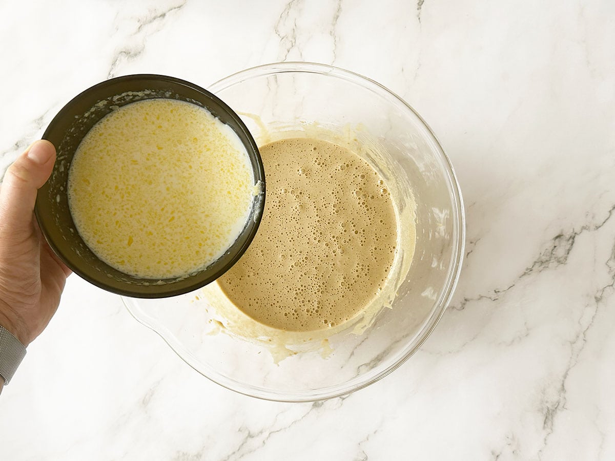 Adding milk, vinegar and butter mixture to Malva pudding batter