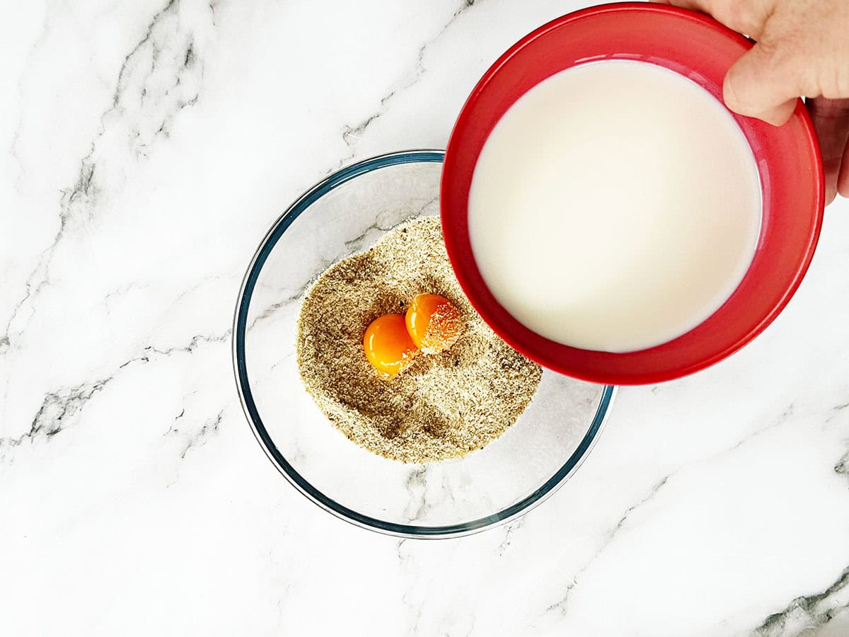 Breadcrumbs, milk and egg yolks combined in bowl for bobotie
