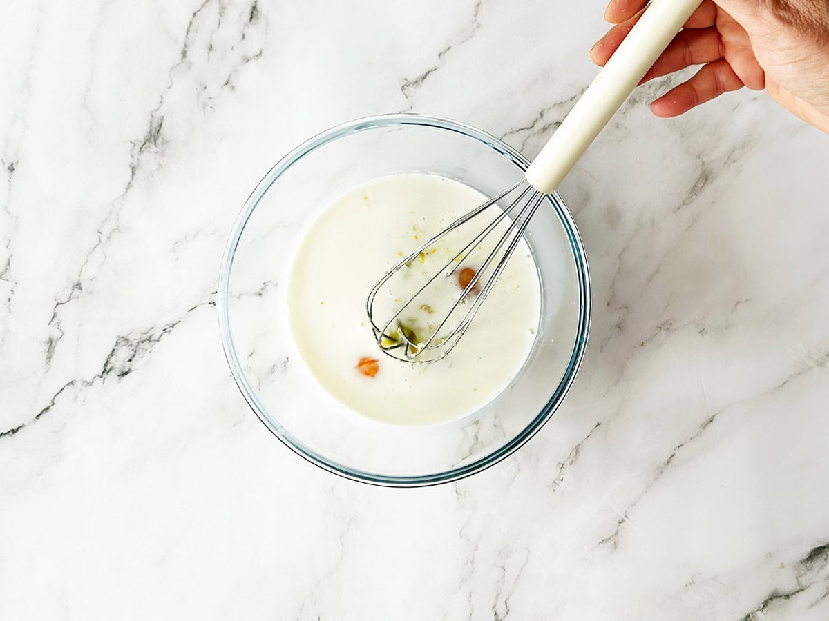 Whisking eggs, milk and lemon zest to make bobotie custard