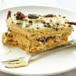 Slice of peppermint crisp tart on a small plate with a bite taken out and a dessert fork
