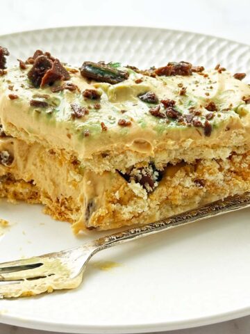 Slice of peppermint crisp tart on a small plate with a bite taken out and a dessert fork