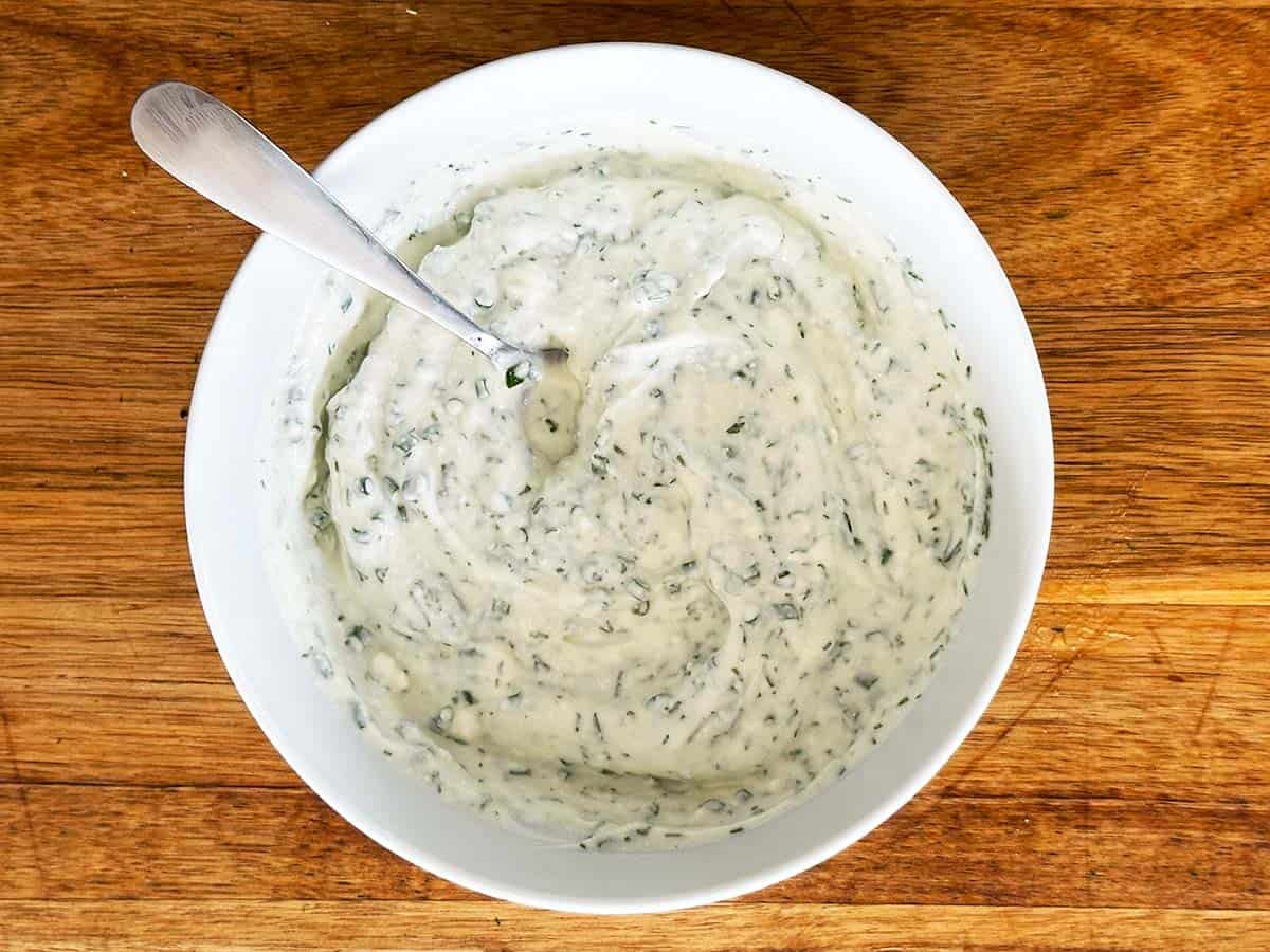 Greek yoghurt ranch dip mixed smooth, resting in bowl.