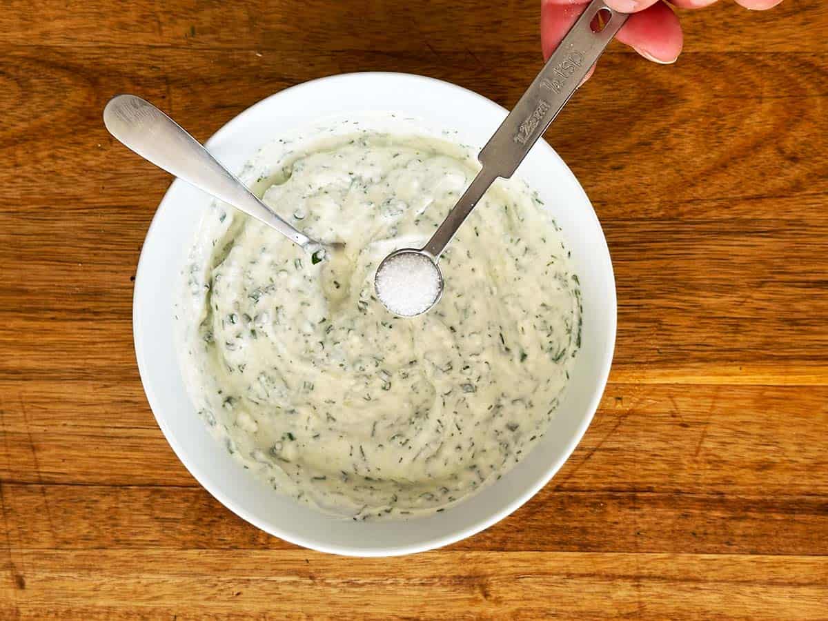 Adding salt to Greek yoghurt ranch dip.