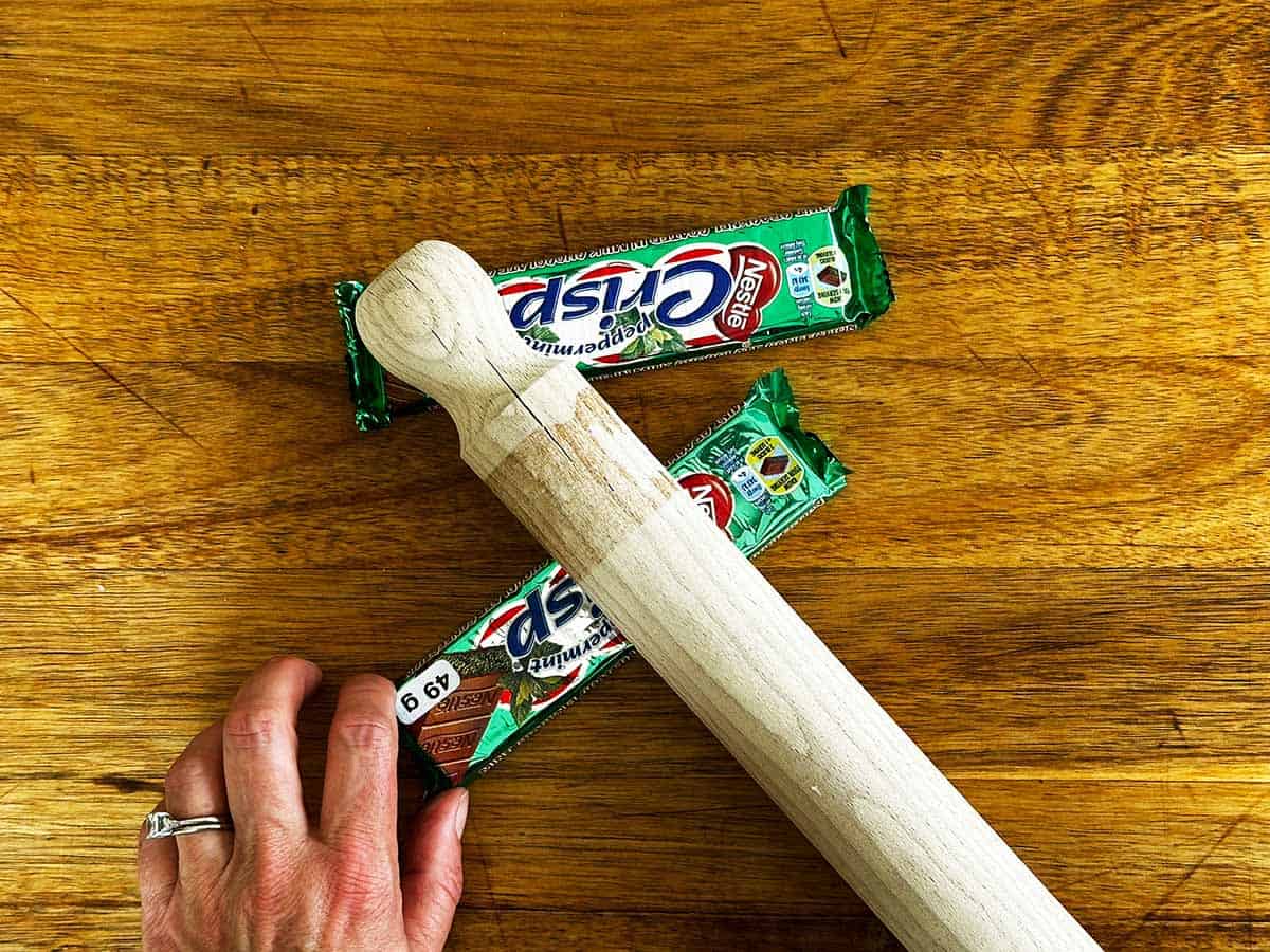 Crushing Peppermint Crisp chocolate bars with a rolling pin for the peppermint crisp tart recipe