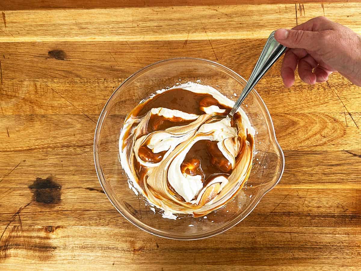 Caramel partially folded into whipped cream for peppermint crisp tart filling