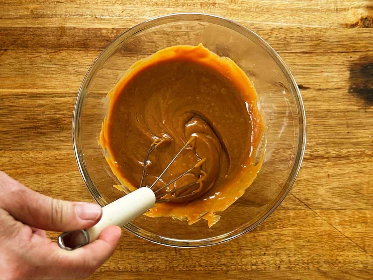 Loosening caramel with a whisk for peppermint crisp tart filling