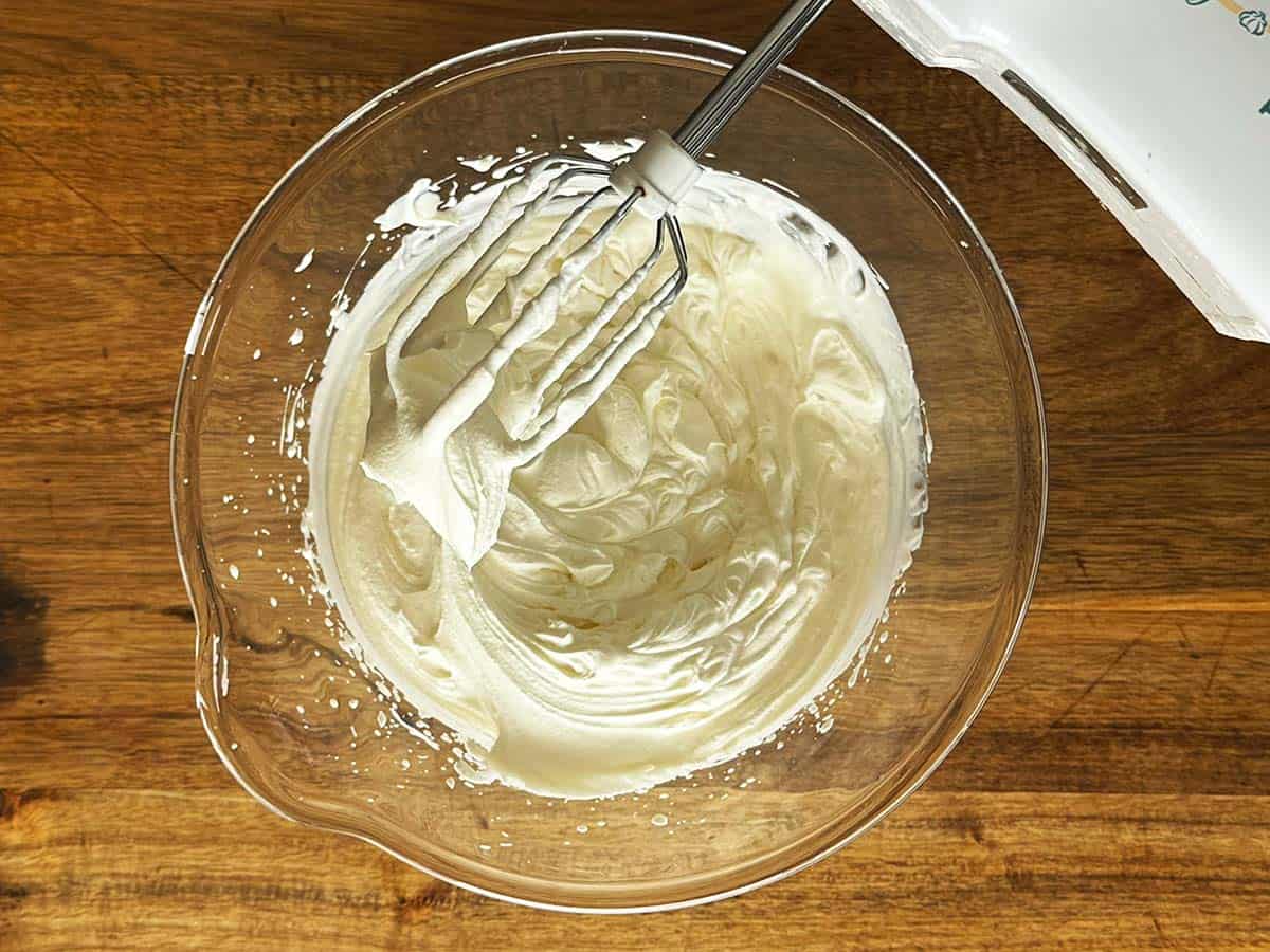Whipped cream at soft peak stage for peppermint crisp tart filling