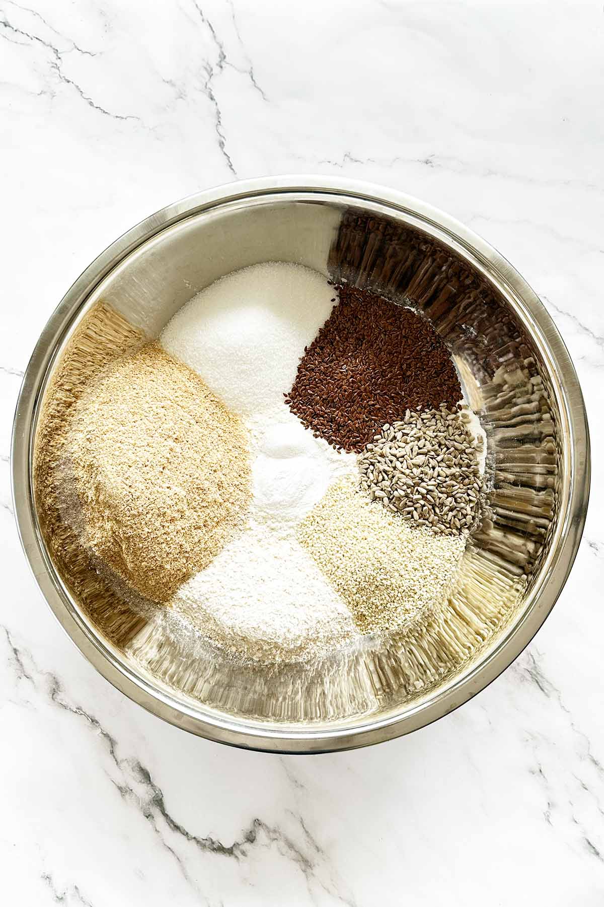 Dry ingredients for seed rusks separated in bowl with seeds
