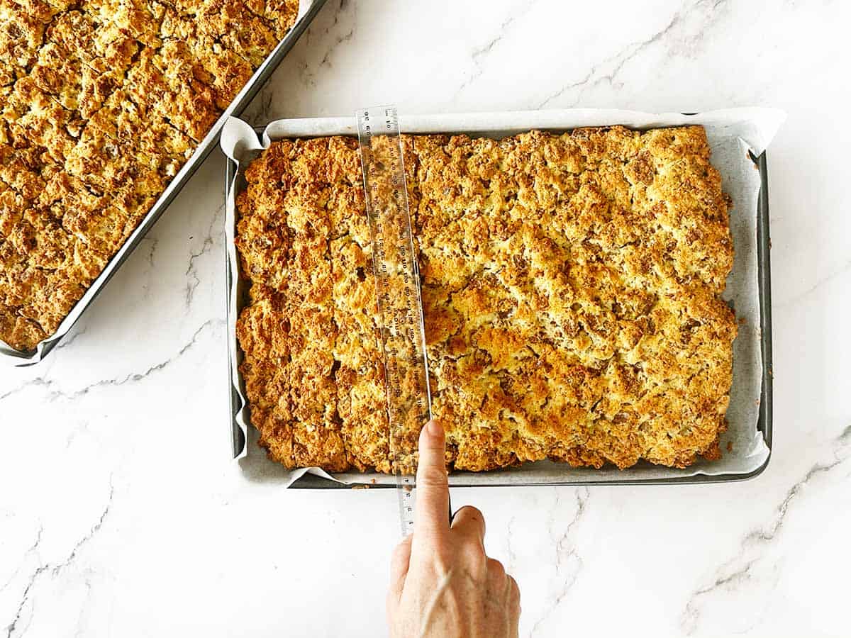 A baked rusk slab cut into neat fingers using a ruler and bread knife