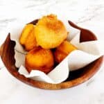 Golden fried vetkoek without yeast piled in a bowl, crisp outside and soft inside
